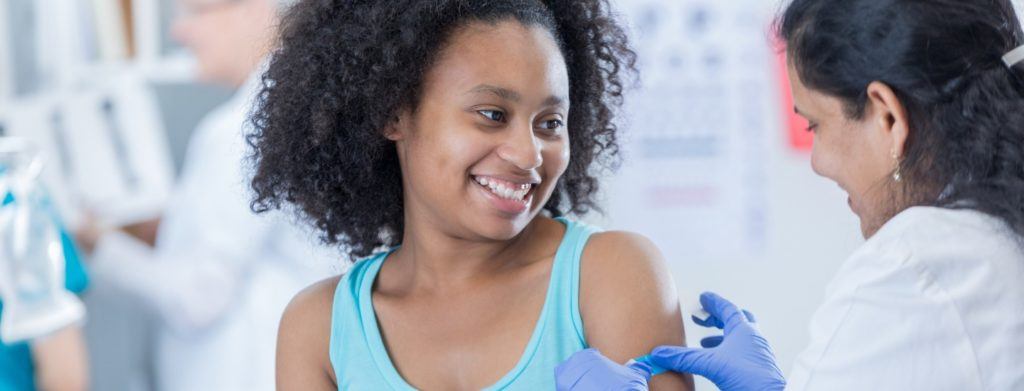 Dortor placing a bandage on a patient after using a syringe